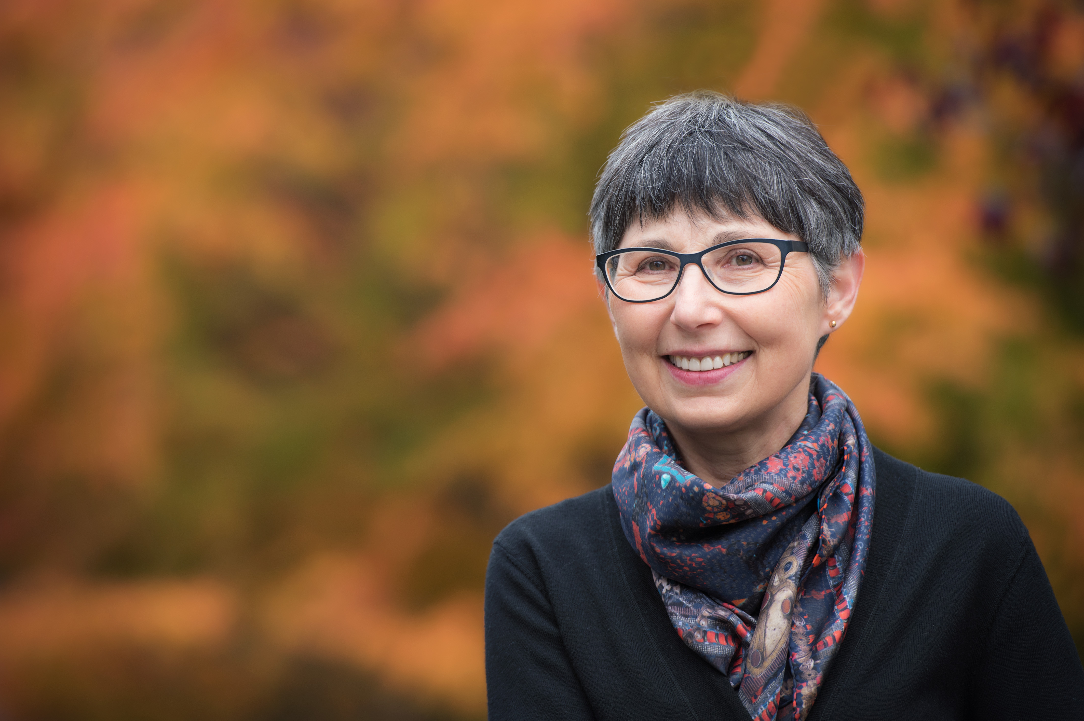 Headshot of Dr. Janet Werker. She is has short, dark hair, glasses and has a dark-coloured scarf around her neck. She is smiling.