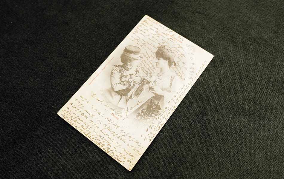 A picture of a postcard from 1902 France, containing a secret love message written in code between two women. This postcard is part of the A Queer Century exhibition on display at UBC until August 30 2019.