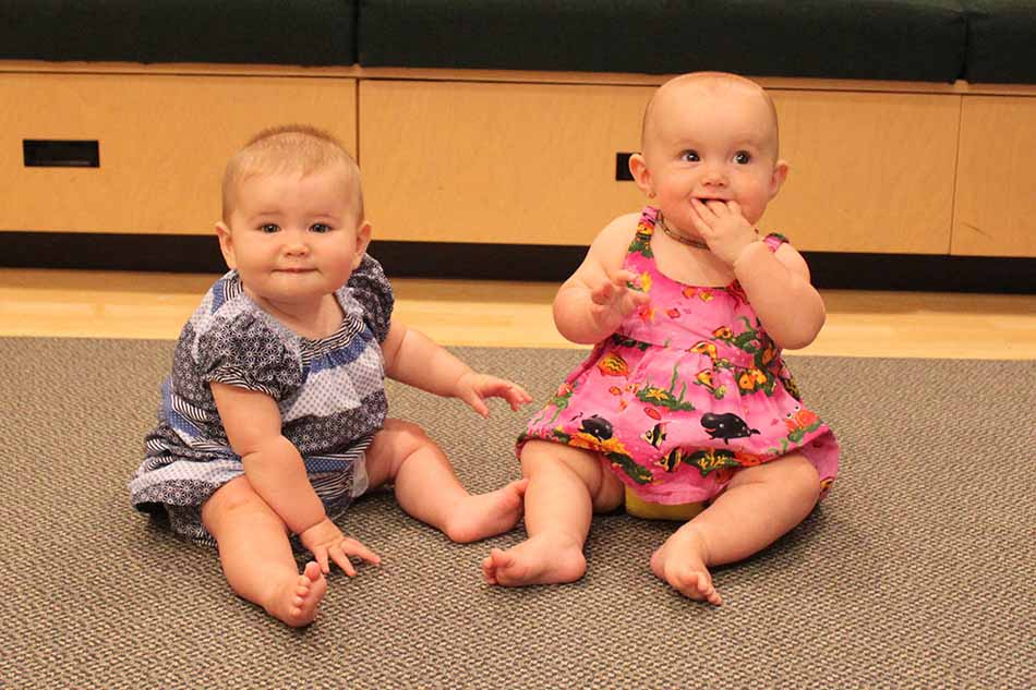This picture of two babies is used to illustrate the story, which details research suggesting that at an early age, infants are attending to and learning from their environment. 