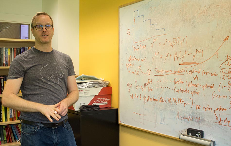 Mark Schmidt is pictured demonstrating some of the principles behind machine learning on a whiteboard.