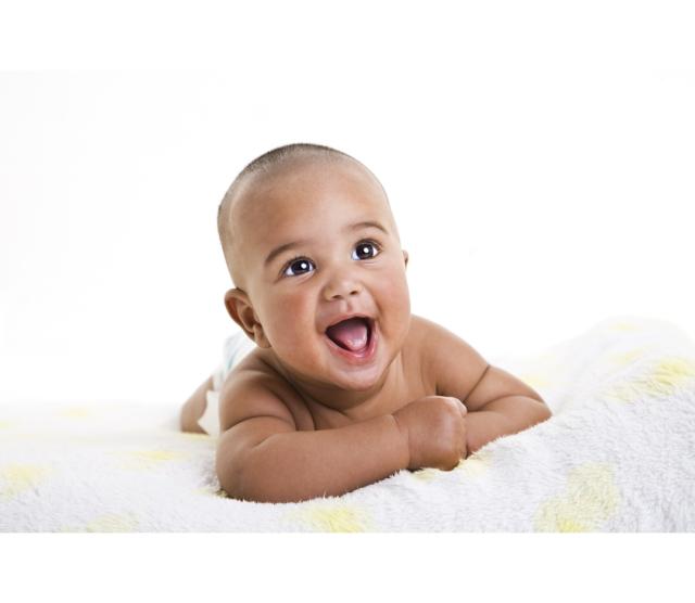Infant laying on stomach on a blanket