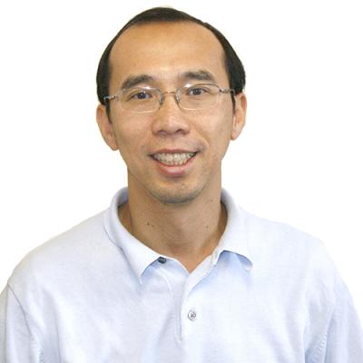 A headshot of Raymond Ng smiling. He is wearing glasses and a white shirt.