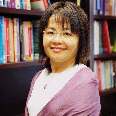 A headshot of Virginia Yip standing in front of bookshelves